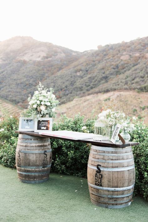 Wedding Aisle Barrels, Barrels Wedding Decorations, Dj Table Wedding, Barrels At Wedding, Barrel Decor Ideas Wedding, Ranch Style Wedding Ideas, Wedding Barrel Decor, Rustic Guest Book Table, Barrel For Wedding