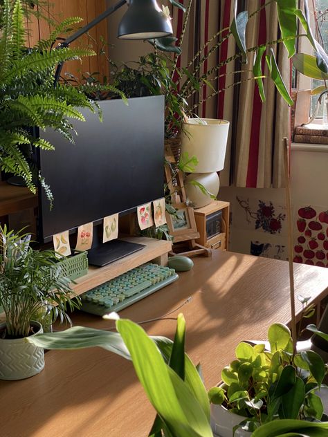 a picture of my desk during the golden hour. desk covered with houseplants. sage green keyboard. gaming setup Room Office Aesthetic, Desks With Plants, Pc Setup Green Aesthetic, Dorm Desk Plants, Office Plants Aesthetic, Greenery Desk Setup, Plant Desk Decor, Studying Desk Setup, Plants On Desk Ideas