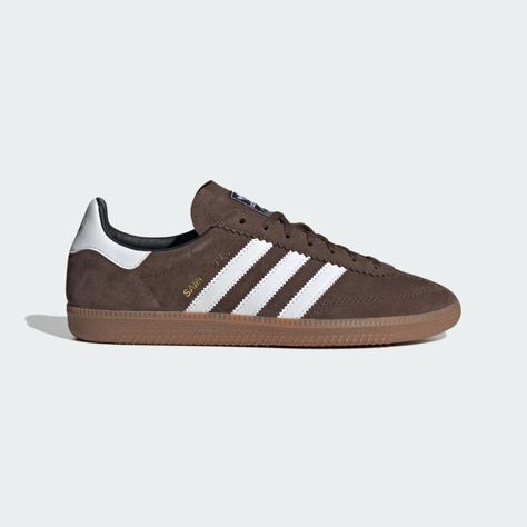 Born on the football pitch, the adidas Samba shoes are a timeless icon of street style. Inspired by a rare 1970s training shoe, this edition is marked by a deco stitch on the toecap for an altered version of the classic Samba T-toe design, as well as a revision to the eye stay and heel mustache to evolve the look of the OG Samba. A suede upper and gum rubber outsole add another nod to retro flair. Brown Adidas, Adidas Samba Outfit, Samba Shoes, Samba Outfit, Sneakers Adidas, Adidas Sneaker, Cooler Look, Cloud White, Adidas Samba