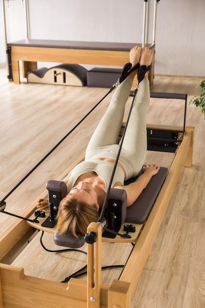 Photo woman training pilates on the refo... | Premium Photo #Freepik #photo #pilates-reformer #yoga-studio #reformer #pilates Reformer Pilates Photography, Nobu Pilates, Poses Pilates Foto, Reformer Pilates Exercises, Pilates Reformer Aesthetic, Pilates Pictures, Pilates Reformer Studio, Sofa Poses, Reformer Pilates Aesthetic