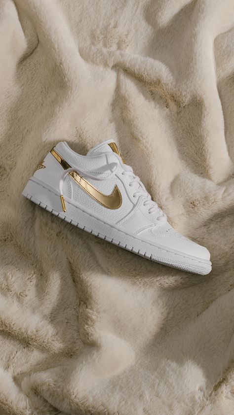 The Air Jordan 1 Low takes on an upscale look with an all-white leather upper with metallic gold finishes. Available now at our Calabasas and Wynn Las Vegas locations + online. Shop Now: https://feature.com/products/air-jordan-1-low-se-womens-white-metallic-gold Gold Air Force 1, Airforce Shoes, Gold Nike Shoes, Jordan Lows, White And Gold Shoes, Festival Outfits Men, Tommy Hilfiger Fashion, Nike Air Force 1 Custom, Wynn Las Vegas