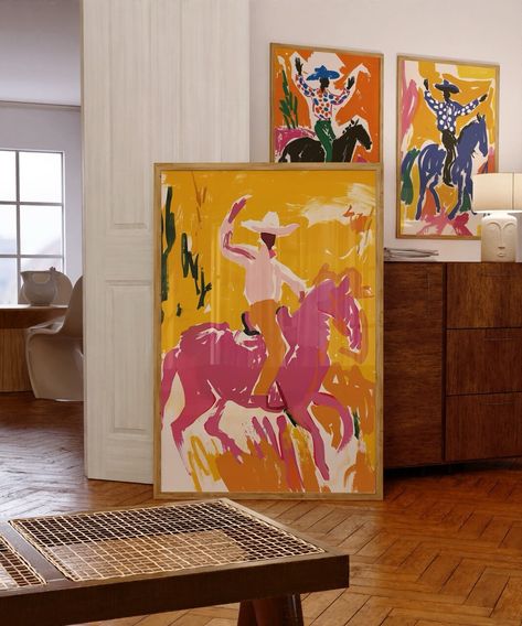 Add a touch of Southwestern flair to your home with this set of 3 vibrant cowboy prints. Each print features a dynamic cowboy scene, rendered in bold, eye-catching colors that capture the spirit of the rodeo. Perfect for adding a pop of color to your living room, office, or bedroom, these prints make a great gift for lovers of Western art and culture. High-resolution digital download Printable in multiple sizes to fit your space Instant download, no physical product will be shipped Unique and co Art Print Living Room, Unique Painting Styles, Interior Design Paintings Wall Art, Modern Western Wall Art, Artful Eclectic Living Room, Funky Colorful Art, Colorful Game Room, Abstract Western Art, Paints For Bedroom Walls