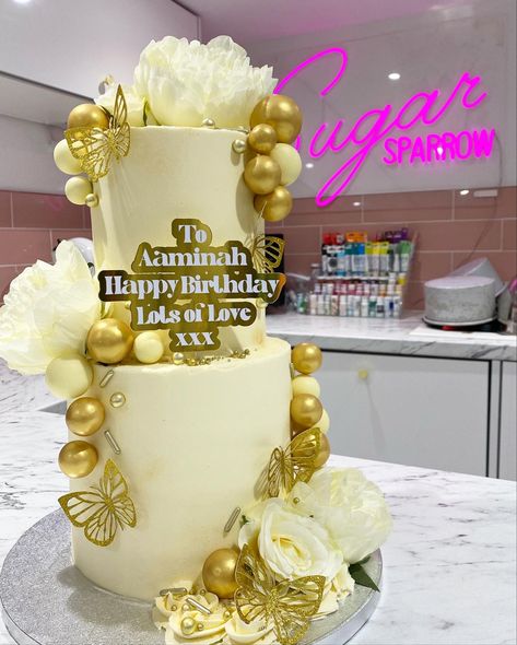 White & Gold 2 tier birthday cake, 
Super classy super girly. With choc balls, butterflies, flowers & sprinkles 3 Tier 21st Birthday Cake, 60th Birthday Cake 2 Tier, Champagne Cake Design, 2 Tier Birthday Cake, Tier Birthday Cake, Moms 60th, Tiered Cakes Birthday, Tiered Cake Design, 60th Bday