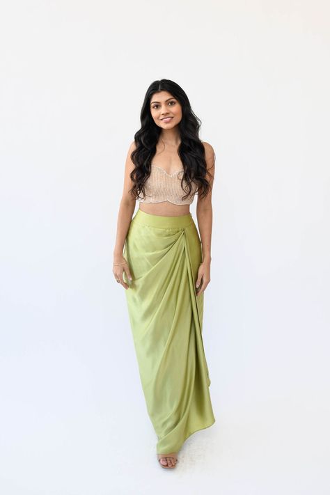 Experience the understated elegance of our Satin Drape Skirt. Crafted with a fitted waistband for a seamless silhouette fit and finished with a timeless drape, this piece is crafted from a luxuriously soft silk satin fabric, perfect for a flowy, feminine look. Features: Zipper and hook closure Fitted waistband Included in purchase: Pista Drape Skirt Side Drape Skirt, Satin Dhoti Skirt, Satin Fabric Dress Design, Satin Skirt Design, Saree Skirt Drape, Dhoti Style Skirt, Dhoti Drape Saree, Satin Draped Skirt, Draping Skirt Design