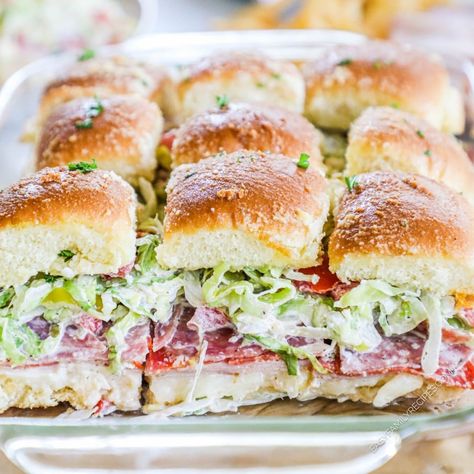 The ultimate flavor-packed delight: Italian Grinder Sliders! These adorable bite-sized versions of the classic grinder sandwich have layers of deli meats, ooey-gooey melted cheese, and an irresistible savory glaze. Trust me, these sliders are like a flavor explosion in every bite! Whether you're hosting a party, looking for a quick and tasty dinner option, or simply want to treat yourself to something scrumptious, these Italian Grinder Sliders are here to satisfy your cravings. Hawaiian Roll Grinder Sliders, Italian Sandwich Sliders, Italian Grinder Sliders Hawaiian Rolls, Italian Sliders Recipes, Pastrami Sliders, Chopped Italian Sliders, Gameday Sliders, Italian Hoagie Sliders, Italian Grinders Sliders