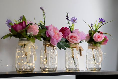 "This is a hand made elegant set of four Fairy Light Mason Jar Centerpieces are perfect for your wedding or event or adding a touch of farmhouse charm to your home decor. You can choose from two sizes: pint or quart, or a set of both. You can also select from six different flower bouquet color variants that match any theme or occasion. Each centerpiece jar comes complete with warm white LED fairy lights, which add a subtle glow to any setting, one silk flower bouquet, and a complementing ribbon, Light Wedding Decor, Mason Jar Light, Lighted Centerpieces, Lights Wedding Decor, Event Centerpiece, Silk Flower Bouquets, Light Wedding, Mason Jar Centerpieces, Farmhouse Wedding