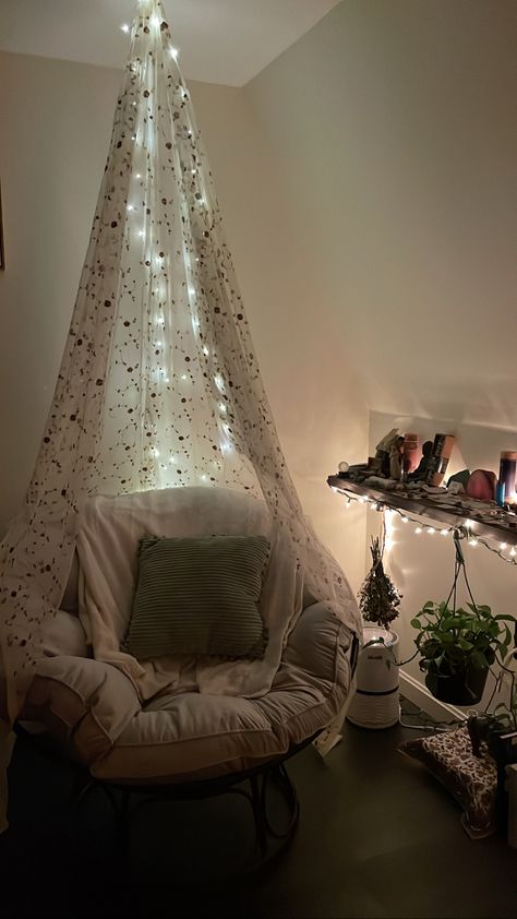 Warm cozy chair with blankets and pillows. A floral canopy drapes over the chair and fairly lights around the canopy Papasan Chair With Canopy, Papasan Chair Canopy, Canopy Over Chair Reading Nooks, Canopy Chair Ideas, Fairy Lights Along Ceiling, Canopy Over Chair, Papasan Chair Bedroom Reading Corners, Cozy Reading Chair Aesthetic, Reading Nook With Fairy Lights