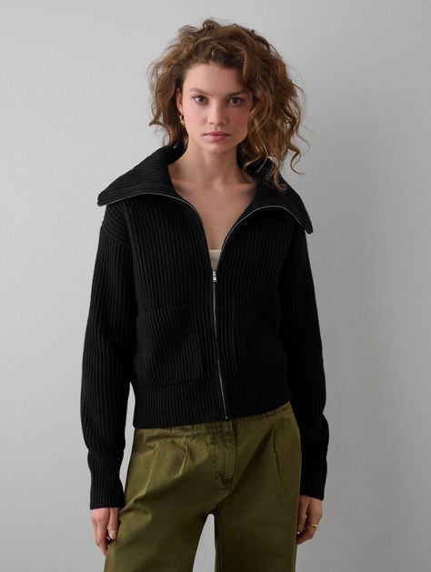 Ethically produced and responsibly sourced, our new Merino Blend Ribbed Zip Up Jacket offers a great new weight and texture to our transitional knitwear collection. With a cropped silhouette, our Zip-Up Jacket feels very much like a bomber style, with side pockets and a neckline that can be zipped up like a turtleneck or left open with a ribbed collar shape. Details Straight fit. Long sleeve. Length in size small is 21". The model is 5'11" and is wearing a size small. 55 % RWS Superfine Merino, Zip Collar, Collar Cardigan, Knitwear Cardigan, Zip Sweater, Lifestyle Shop, Black Rib, Brand Colors, Layering Pieces, Sweater Jacket