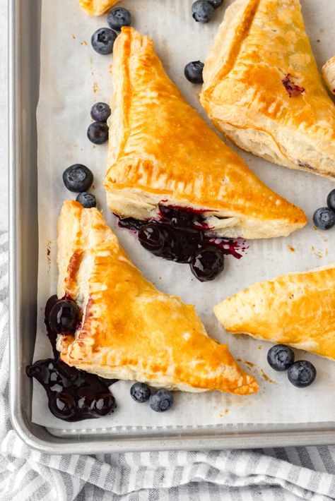 Blueberry turnovers on a sheet pan. Recipe Using Puff Pastry, Recipes Using Puff Pastry, Blueberry Turnovers, Using Puff Pastry, Phyllo Recipes, Blueberry Filling, Puff Pastry Recipe, Canned Blueberries, Turnover Recipes