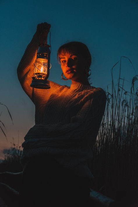 Girl holding lantern up to her face in the late evening light. Shot in Latvia. Lantern At Night, At Night, Lighting