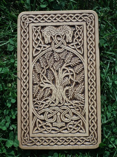 The wood carving is loosely inspired by Norse and Viking mythology. The main motif is the World Ash Tree Yggdrasil. At the top of this wood carving are two horses pulling a chariot of the sun gods. The ring in the entanglement can symbolize the Sun. Thor's hammer among the intertwined snakes is at the bottom. In this case, it is a depiction of a flying hammer as a symbol of protection against underworld beings, which are expressed here by intertwined snakes. Viking Carving Pattern, Norse Wood Carving, Celtic Wood Carving, Norse Carving, Viking Sculpture, Viking Wood Carving, Intertwined Snakes, Viking Chair, Sun Gods