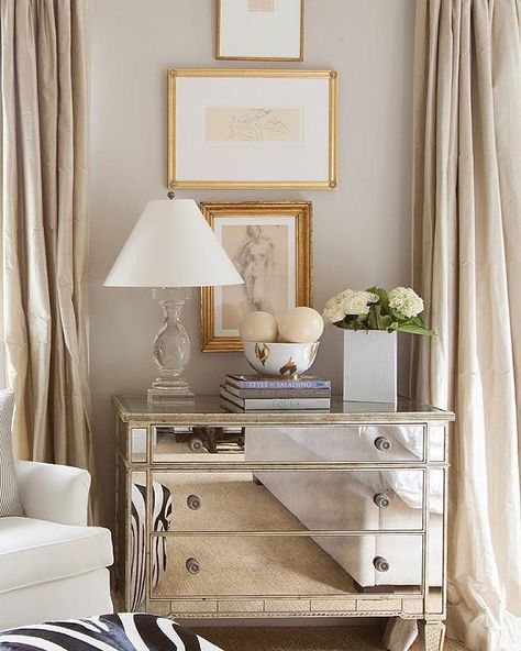 Elegant bedroom features stacked abstract nude sketches placed over a mirrored dresser topped with a crystal baluster lamp and a Nate Berkus Ikat Bowl flanked by windows dressed in champagne colored silk curtains. Mirrored Dresser, Nate Berkus, A Living Room, Zebra Print, Dresser, Curtains, Living Room, Bedroom, Wall