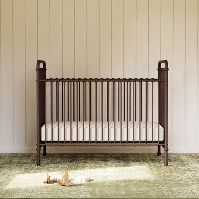 Inspired by vintage American metal cribs, the Abigail 3-in-1 Convertible Crib is made of premium steel and is available in a variety of finishes. With traditional metal casting at the joints and simple curves, Abigail completes your classic nursery. Color: Vintage Iron | Namesake Abigail 3-in-1 Convertible Crib 44.0 H x 29.5 W in brownMetal in Vintage Iron | Standard | Wayfair Dark Nursery Furniture, Ralph Lauren Nursery Baby Boy, Black Metal Crib, Brown Nursery Ideas, Classic Boy Nursery, Dark Wood Crib, Dark Wood Nursery, Metal Cribs, Vintage Baby Cribs