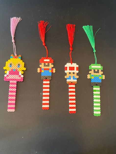 Mario Brothers characters Handmade perler bead Bookmark with tassel Hama Beads Bookmark Ideas, Cute Perler Bead Bookmarks, Teacher Perler Bead Patterns, Perler Beads Cute Ideas, Hama Bookmarks, Pearler Bead Bookmark, Perler Bookmark, Perler Beads Bookmark, Mario Brothers Characters