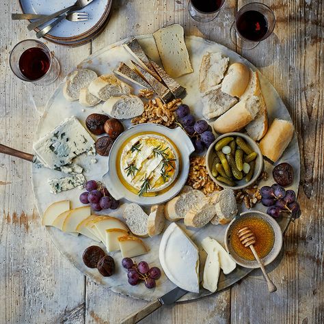 A wooden grazing board with various cheeses and ramekins English Cheese Board, British Cheese Board, French Inspired Charcuterie Board, Rustic Cheese Board, Manchego Cheese Board, Charcuterie Board French, Italian Cheese Board, Cheese Board Aesthetic, Brie Cheese Board