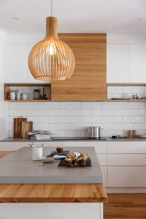 Grand modern. Featuring a solid Blackbutt timber rangehood in a horizontal grain with American Oak solid timber shelving on either side. #kitchendesign #kitchens #modern #timber #caesarstonebenchtops #subwaytile  #interiordesign #spacecraft #spacecraftjoinery #everythingwedoisbuiltaroundyou