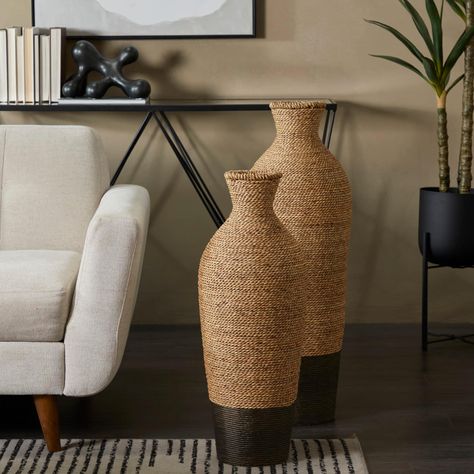 "Buy the Brown Seagrass Handmade Tall Woven Floor Vase at Michaels. com. A boho inspired style that exudes creative form with a free-spirited design. This brown round vase is made of seagrass, iron, and polyethylene materials for robust structure. A boho inspired style that exudes creative form with a free-spirited design. This brown round vase is made of seagrass, iron, and polyethylene materials for robust structure. It features a two-tone color trend with a light natural brown top section and Floor Vases Decor, Seagrass Table, Pampas Grass Vase, Farmhouse Vase, Tall Floor Vases, Dried Pampas, Flower Vases Decoration, Colored Vases, Living Room Area