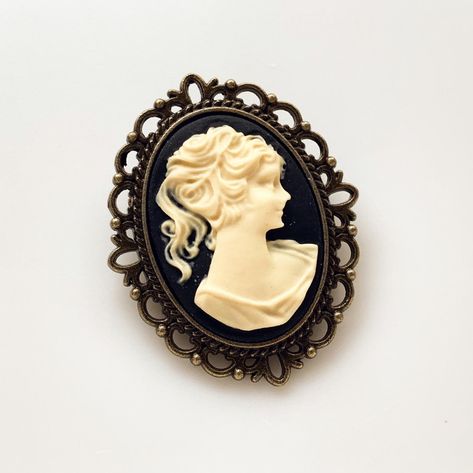 Cameo Brooch Vintage Lady Pin Brooch Bouquet Victorian Costume Cameo Jewelry -I make this brooch using a black and cream cameo and set it in an antique brass setting -Nickel free lead free alloy metal, resin cameo, C clasp closure -Measures 1 1/4" x 1 1/2" -Gift Boxed More of my Cameo Jewelry: https://www.etsy.com/shop/lydiasvintage?search_query=cameo More of my Brooches: https://www.etsy.com/shop/lydiasvintage?ref=seller-platform-mcnav§ion_id=6786664 Camphor Glass Jewelry, Bridesmaid Favors, Victorian Costume, Gothic Victorian, Cameo Jewelry, Vintage Lady, Brooch Bouquet, Victorian Lady, Vintage Cameo