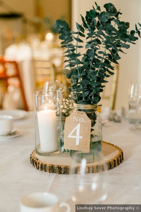 Mark and Rebecca's wedding in Alton, Ontario - WeddingWire.ca Candle And Mason Jar Centerpieces, Wedding Table Decor With Greenery, Modern Rustic Theme Wedding, Sage Green And Grey Wedding Centerpieces, Mason Jar Table Numbers, 1 Tier Wedding Cake Rustic, Dried Eucalyptus Centerpiece, Rustic Wedding Table Decor Mason Jars, Rustic Modern Wedding Centerpieces