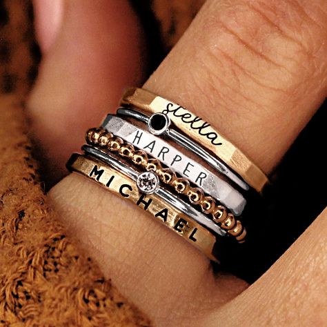 Personalized stackable ring set, engraved with names, dates, or special words. All 6 rings shown in the photos are included in this listing.  Choose between mixed metals, fine silver, or 14K yellow gold-filled for your set! MIXED METALS include: 2 - yellow gold-filled name rings 1 - fine silver name ring 2- sterling silver birthstone rings 1 - yellow gold-filled beaded ring This ring set includes three name rings, a beaded ring, and two cz rings Metal: 14k gold filled, .999 fine silver, .925 sterling silver Dimensions: name rings are 2mm tall on average, but our rings are handmade so variations will occur. The beaded ring is 2mm, and the birthstones are 2mm on a 1mm band (one sterling silver, one 14k gold filled). Font: lowercase cursive, uppercase thin block, uppercase thick block Unsure Personalized Stackable Rings, Stackable Name Rings, Grandmother Jewelry, Stacked Rings, Rings Stacking, Necklace Combo, Ring Cuts, Ring Spacer, Name Ring