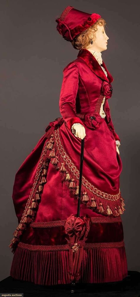 29" figure, period accurate 1885 visiting dress created & hand sewn by fashion designer John Burbidge: deep red silk satin & velvet bustle skirt & jacket, lace blouse, fringed & tasseled over skirt, includes matching parasol & hat, shoes, undergarments, all excellent. This is one of 75 "ladies" each costumed in a 1860 through 1914 unique ensemble, as seen in the book "Les Petites Dames de Mode" & numerous museum presentations throughout the U.S. 1880s Fashion, Bustle Dress, Period Dress, Victorian Costume, Fashion D, 19th Century Fashion, Victorian Clothing, Vintage Gowns, Antique Clothing