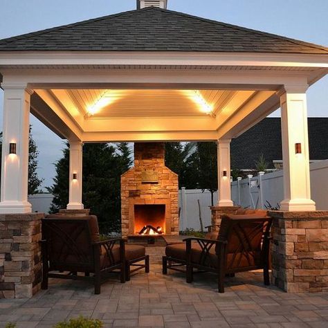 At the edge of a patio, beside a lovely shingle-roof pavilion, this fireplace not only offers warmth in autumn and winter months but it creates the perfect ambience for conversation. www.longislandhottub.com Fireplace Construction, Fireplace Plans, Gazebo Lighting, Capira, Diy Outdoor Fireplace, Cheap Pergola, Outdoor Pavilion, Backyard Fireplace, Backyard Gazebo