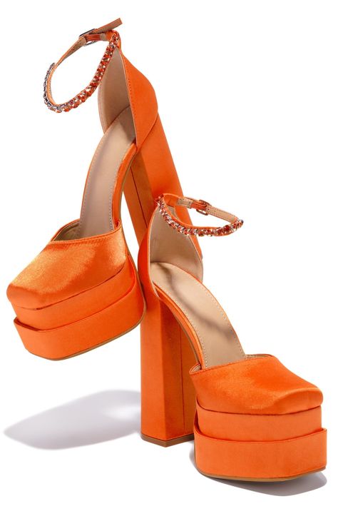 SIZE & FIT HEEL HEIGHT APPROX: 6" PLATFORM HEIGHT APPROX: 2" SIZE DOWN - MODEL WOULD GO DOWN 1/2 SIZE ALL MEASUREMENTS ARE MADE ON A SIZE 6.5 THERE MAY BE SLIGHT MEASUREMENT VARIATIONS BASED ON SIZE. PRODUCT DETAILS ADJUSTABLE AROUND THE ANKLE BUCKLE CLOSURE ORANGE STONE EMBELLISHMENTS CHUNKY HEEL CLOSED ROUNDED TOE LIGHTLY PADDED INSOLE ORANGE FAUX SATIN PLATFORM HEEL FLASH PHOTOGRAPHY & EDITING HAVE BEEN USED TO ENHANCE EMBELLISHMENTS Talon Versace, Orange Platform Heels, Orange High Heels, Versace Heels, Orange Heels, Orange Stone, Orange Shoes, Rhinestone Decor, Flash Photography