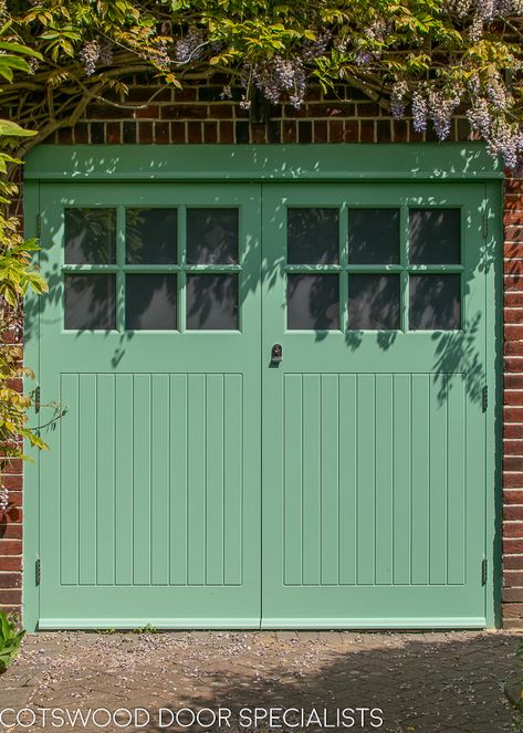 A pair of classic Art deco 1930s garage doors with vertical tongue and groove style boarding. The doors are side hinged and have been equipped with traditional door stays to hold each door open. Six square obscured glass panels in each door permit lightflow into the garage. Painted in a fresh mint green and fitted with polished chrome door furniture, these 1930s garage doors and matching 1930s front door create a charming first impression of this London home. Garage Doors Uk, Side Hinged Garage Doors, Garage Door Colors, Garage Door Hinges, Wooden Garage Doors, Garage Door Styles, Mews House, Wooden Garage, Contemporary Doors