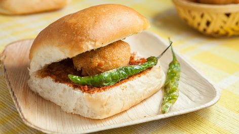 #MumbaiStreetFood Day 1 Vadapav - Do you know Bombay / Mumbai got its first vada pav in 1970? The first man who made it was Ashok Vaidya. It is also called as Bombay Burger. Vada comes from the Marathi compound word batata vada, which means "potato fritter". The dish consists of a deep fried potato dumpling placed inside a bread bun (pav) sliced almost in half through the middle. It is generally accompanied with one or more chutneys and green chilli pepper. #Vadapav #streetfood #mumbai #food Vadapav Logo, Vadapav Snap, Vada Pav Recipe, Potato Dumpling, Batata Vada, Apple Chips Recipe, Pav Recipe, Mumbai Street Food, Fried Potato