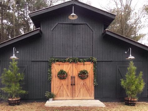 Beautiful black barn with stained barn doors and barn lights. Barn Light Electric, Barn Shop, Outdoor Barn Lighting, Barn Renovation, Best Barns, Barn Garage, Black Barn, Barns Sheds, Metal Barn