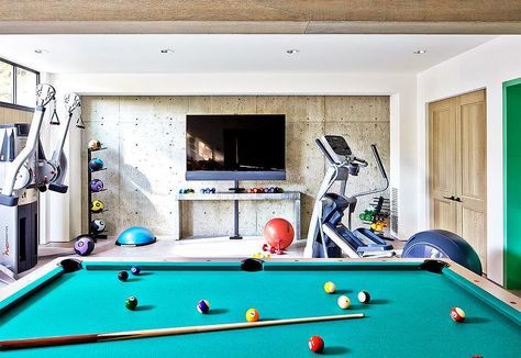 Basement game room and gym boasts a pool table facing a flatscreen TV over a concrete waterfall console table alongside gym equipment. Retro Gamer Room, Gamer Room Ideas, Cottage Basement, Basement Gym Ideas, Contemporary Basement, Sofa Contemporary, Garage Game Rooms, Basement Games, Retro Games Room