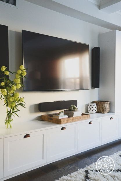 white built-in with shaker style cabinets under the wall mounted tv. This TV room has some serious surround sound! Decorate a media console with a tray and home decor. A tray is perfect for displaying accessories in because you can move it in a pinch AND use it to serve guests. Family Room Inspiration, Cozy Family Rooms, Muebles Living, Flat Screen Tv, Living Room Tv Wall, Family Room Design, Living Room Storage, Living Room Tv, Lounge Room