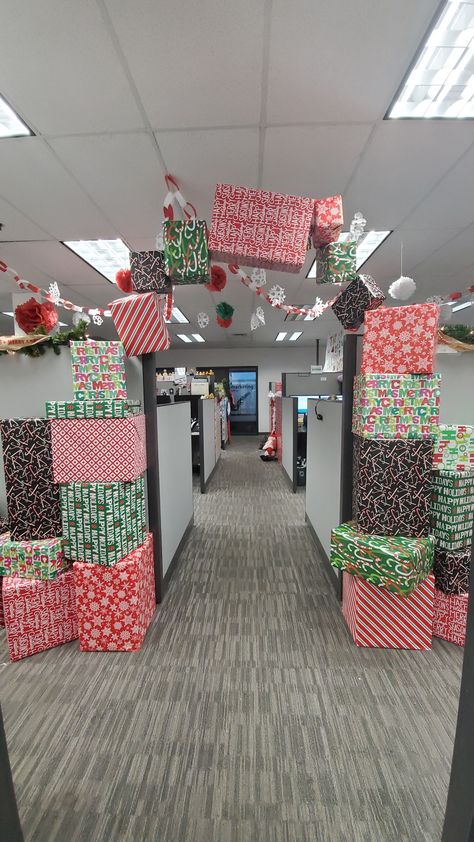 Wrapped boxes with gift wrap from the dollar tree, stacked them, then hung others with fishing line from the ceiling grid Natal, Christmas Decor Desk Office, Hanging Presents From Ceiling, Office Christmas Decorations Ideas, Christmas Cube Decorations, Holiday Desk, Christmas Ceiling Decorations, Christmas Cubicle, Cubicle Decorations