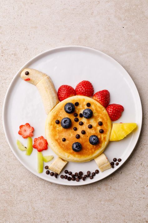 Dinosaur Mini Pancakes Dinosaur Pancakes For Kids, Pancake Designs For Kids, Frog Pancakes, Fun Fruit Ideas For Kids, Disney Pancakes, Pancake Plating, Pancake Decoration, Dinosaur Pancakes, Dinosaur Food Ideas