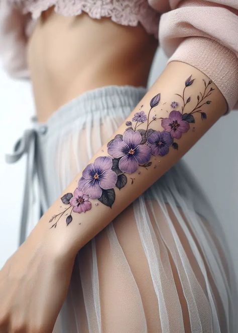 "Violet Whispers: Adorn your skin with the February birth flower—the violet. Its deep purple hues and heart-shaped petals evoke mystery and elegance. This delicate garland tattoo whispers secrets of love, resilience, and the beauty found in life’s quiet moments." 💜🌿 Beautiful Heart Tattoo, Purple Violet Flower Tattoo, Tattoos 2024 Woman, Butterfly Cherry Blossom Tattoo, Tattoos Of Violets, Flower Tattoos Purple, February Birth Flower Tattoo Violets, Violet Flower Tattoo Designs, Violet Birth Flower Tattoo