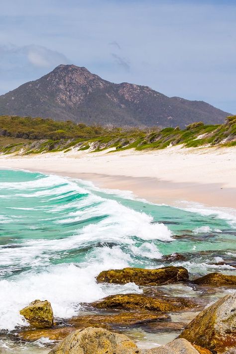 Gleaming white sands and aquamarine waters form the wide arc of Wineglass Bay, a breathtaking beach on the Freycinet Peninsula. This remote paradise is renowned for its beauty and is an idyllic spot to stop for a swim or a beach stroll. Accessible only via a bushland walking track or a scenic cruise, Wineglass Bay is an ideal daytrip within the pristine Freycinet National Park. 🌊 Start planning your trip with our travel guides. Beaches In The World, Hawaiian Islands, Tasmania, Plan Your Trip, Travel Guides, Us Travel, Day Trips, Aquamarine, Travel Guide