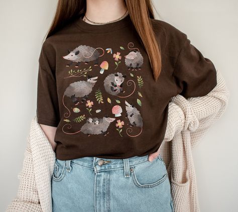 Cute Cottagecore Possum Gift for people that are opossum fans or opossum lovers and for cottage core aesthetic lovers. Add this super soft Cottagecore Clothing to your Aesthetic clothing collection. Available on tshirt, sweatshirt and hoodies: https://www.etsy.com/shop/TheNims?search_query=possum For other Christmas items, click here: https://www.etsy.com/shop/TheNims?r&section_id=30682947 Browse through my other awesome items here: http://thenims.etsy.com/ UNISEX TEES Gildan 5000™ (CUSTOMER FAV Possum Shirt, Cottage Core Clothes, Soft Cottagecore, Aesthetic Lovers, Cottage Core Shirt, Christmas Kawaii, Cute Cottagecore, Cottage Core Aesthetic, Aesthetic Clothing