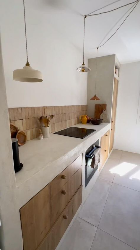 This Mediterranean-inspired kitchen blends rustic and contemporary elements with stucco countertops, wood cabinetry, and rattan pendant lights. An integrated bench with plush cushions adds comfort. Earthy tones and minimalist decor enhance the coastal vibe. SHOP similar products tagged. #MediterraneanKitchen #RusticCharm #StuccoCountertops #WoodCabinetry #RattanPendants #BenchSeating #MinimalistDecor #EarthyTones #CoastalVibe #HomeDecor #KitchenDesign #Benchseatingc#rattan #rattandecor Modern Mediterranean Kitchen, Mediterranean Style Kitchen, Cement Kitchen, Mediterranean Kitchen Design, Rattan Pendant Lights, Countertops Wood, Mediterranean Interior, Mediterranean Kitchen, Rattan Pendant