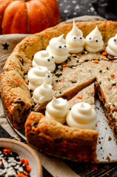 Turn any cookie cake into a Halloween spectacle with simple frosting ghosts. This easy Halloween cake recipe features chocolate chips and festive sprinkles for a fun Halloween cookie cake for kids and adults alike. This is a great option for Halloween potluck ideas for work or a Halloween party dessert recipe. Everyone will want more of this Halloween chocolate chip cookie cake. | halloween cookie cake designs easy | halloween cookie cake recipe | how to make frosting ghosts Halloween Crispy Cakes, Fall And Halloween Baking Ideas, Halloween Desserts For Contest, Halloween Finger Food Desserts, Halloween Slice And Bake Cookies, Halloween Pot Pie, Monster Mash Cake, Halloween Molds Ideas, Halloween Cookie Cakes Ideas