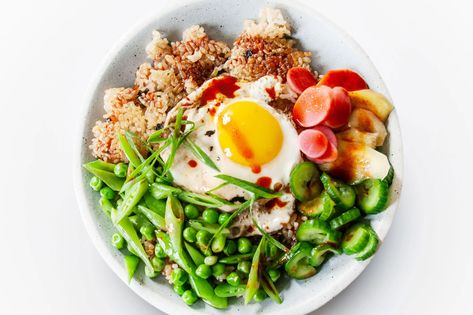 This dish was closely inspired by Korean bibimbap, a bowl or pot of rice topped with an assortment of vegetables, an egg, and (sometimes) meat that's mixed together right before it's eaten. But even though bibimbap, which has existed for centuries in Korea, is extremely customizable, this recipe isn't bibimbap exactly: It doesn't include some of the usual players, like cooked soybean sprouts, blanched spinach, and julienned carrots; it leans heavily into the crispy rice (which is only achieved w Crispy Rice Bowl, Blanched Spinach, Soybean Sprouts, Spring Vegetables Recipes, Korean Bibimbap, Julienned Carrots, Crispy Rice, Vegetarian Chili, Spring Vegetables