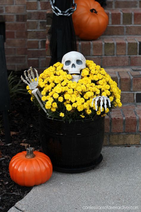 Outdoor Halloween display Front Halloween Decorations Porch, Skeleton Front Door Decor, Diy Halloween Front Yard, Halloween Porch Pots, Halloween Outdoor Pots, Halloween Front Porch Planters, Porch Decorating For Halloween, Halloween Porch Planter Ideas, Diy Halloween Pumpkin Arch