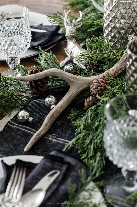 This rustic woodland centerpiece was created using greenery, mercury glass, silver deer, and antlers. #christmas #tablescape #centerpiece #christmastablescape #andersonandgrant Natal, Woodland Christmas Table, Woodland Centerpiece, Viking Christmas, Woodland Christmas Decor, Antler Christmas, Noel Fisher, Diy Deco Noel, Christmas Dining Table