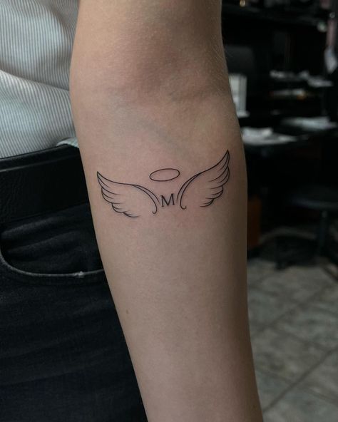 Best 70+ Wing Tattoo Designs Ideas - May 2024 Forearm Tattoo Women Angel Wings, Wings With Letter Tattoo, M With Angel Wings Tattoo, Tattoo With The Letter A, Angel Tattoo With Initials, Letter With Angel Wings Tattoo, Letter M Tattoo Designs, Tattoo Below Elbow, Angel Tattoo Designs For Women