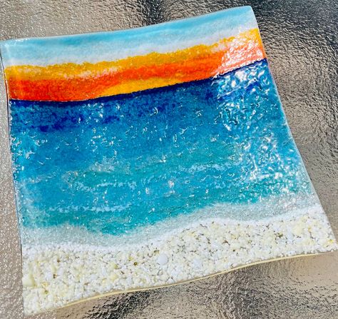 "Fused glass beach sunset plate with relaxing sandy beach in French Vanilla and white. Aqua, turquoise, and blue for the water and waves. Yellow, orange, and lightly cloudy blue sunset skies... The wavy edges of this dish look like ocean waves are flowing towards the shore :) This unique platter was hand painted with permanent fusible paint which was fired in the kiln (lead free and food safe). Colorful crushed glass was added on top and you can feel its beautiful texture.  Please note that all Beach Platter, Beach Fused Glass Ideas, Fused Glass Sunset, Fused Glass Beach, Fused Glass Wave, Fused Glass Ocean Waves, Fused Glass Beach Scene, Fused Glass Underwater Scene, Fused Glass Plates Bowls