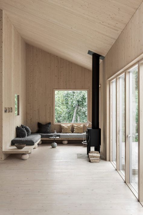 Peek Inside a Minimal Getaway in Sweden | a warm wood interior with wood clad walls, ceiling and floor, a wrap around sofa and black wood burner #nordicinterior #woodcabin #scandinavianstyle Scandinavian Cabins, Contemporary Cabin, Plywood Interior, Interior Boho, Cabin Interiors, Hus Inspiration, Modern Cabin, Wood Interiors, Cabin Design