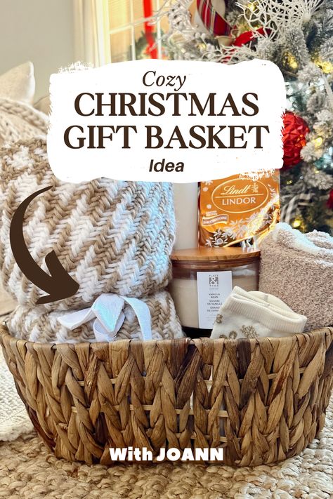 Cozy Christmas Basket from JOANN: blanket, candles, chocolates, tumblers—curated by She Gave It A Go! 🎁✨ #handmadewithjoann #HolidayJoy #CozyHome Cozy Blanket Gift Basket Ideas, Christmas Wicker Basket Ideas, Christmas Blanket Gift Ideas, Family Baskets For Christmas, Cozy Themed Gift Basket, Gift Basket Ideas Under $25, Blanket Basket Gift Ideas, Cozy Christmas Gift Ideas, Comfy Gift Basket Ideas