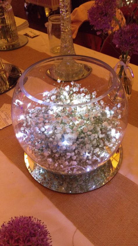 Gypsophila fishbowl with fairy lights Fish Bowl Centerpiece Wedding, Vintage Wedding Decorations Diy, Fishbowl Centerpiece, Thanksgiving Dinner Table Setting, Fairytale Wedding Decorations, Fairy Lights Wedding, Fairy Lights Decor, Lighted Centerpieces, Dinner Host