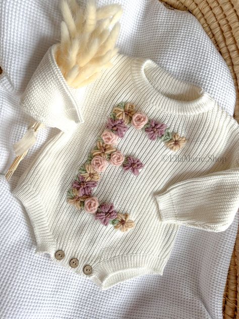 Our hand-embroidered floral initial romper is the perfect addition to your little one's wardrobe or a thoughtful gift for baby showers, baby reveals, or pregnancy announcements. Each romper is meticulously crafted with soft, breathable fabric to keep your baby comfortable all day long. The beautiful floral design adds a touch of whimsy and sweetness, making it a delightful outfit for any occasion. What makes this romper truly special is the custom embroidery of your baby's initial on the front. Baby Hand Embroidery Designs, Embroider Baby Clothes, Nursery Embroidery Ideas, Embroidered Baby Onesie, Crochet Baby Things, Summer Newborn Outfits, Baby Clothes Embroidery, Embroidered Kids Clothes, Embroidery Kids Clothes