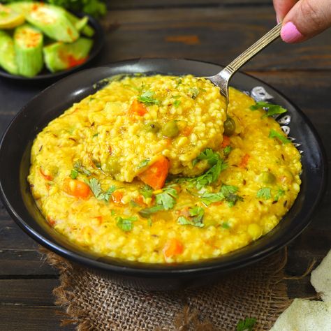 Vegetable Dalia Khichdi is a nourishing Indian khichdi made with broken wheat (dalia), moong dal, and vegetables in a pressure cooker. Khichdi Instant Pot, Dalia Khichdi Recipe, Vegetable Khichdi Recipe Indian, Daliya Khichdi, How To Make Khichdi, Bengali Khichdi Recipe, Ayurvedic Cooking, Diwali Animation, Dal Khichdi