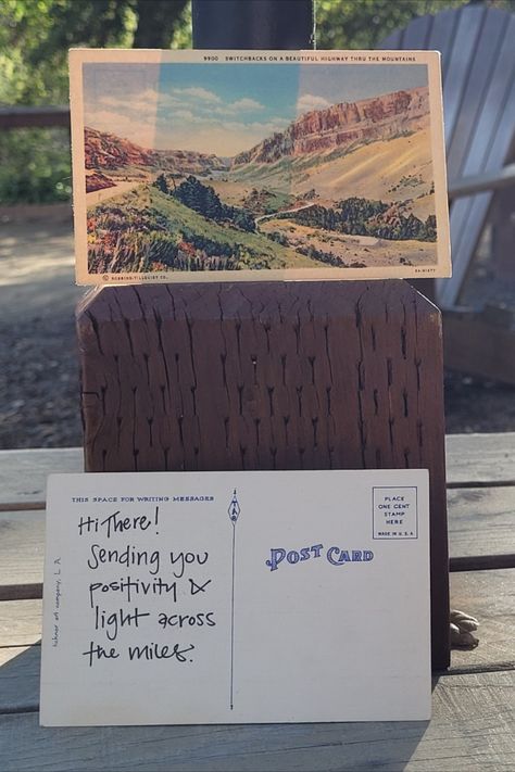 Two postcards propped up on a wooden table with a campsite in the background. A positive message is written on the back of one of the postcards. Post Card Messages Ideas, Postcard Writing Ideas, Post Card Design Creative, Postcrossing Ideas, Postcard Writing, Postcard Letter, Post Card Design, Postcards Inspiration, Postcard Ideas